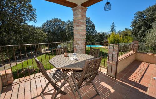 a wooden table and chairs on a deck at Cozy Home In Méjannes-Lès-Alès in Méjannes-lès-Alès