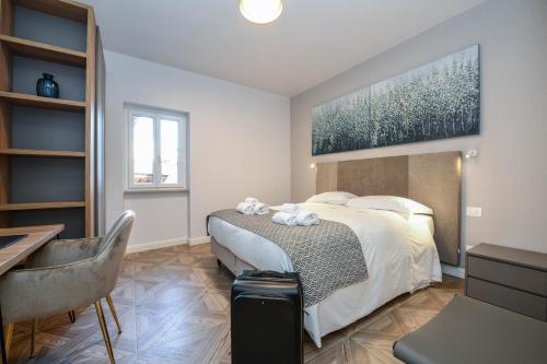 una camera con letto, tavolo e scrivania di Madalì Suite & Apartments Brescia a Brescia