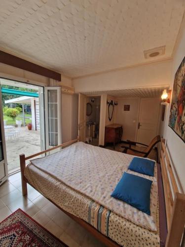 een slaapkamer met een groot bed met blauwe kussens bij Maison Jeanne in Saint-Louis