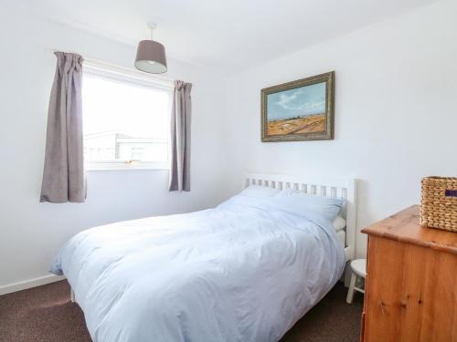 a bedroom with a white bed and a window at Chalet 150 in Great Yarmouth