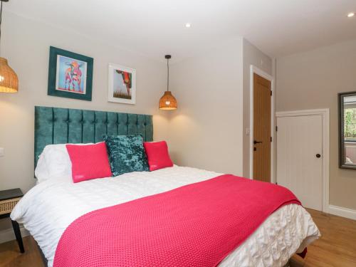 a bedroom with a large bed with a pink blanket at Sevenwoods View in Longhope