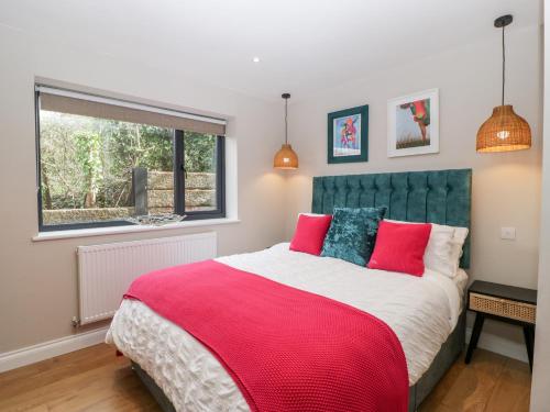 a bedroom with a large bed with a red blanket at Sevenwoods View in Longhope