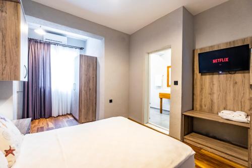 a hotel room with a bed and a tv on the wall at Hotel Centro Bodrum in Bodrum City