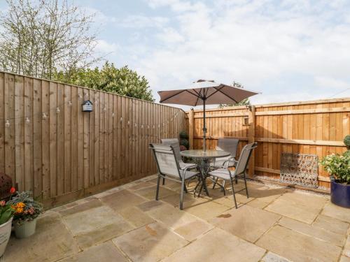 a patio with a table and chairs and a fence at Sevenwoods View in Longhope
