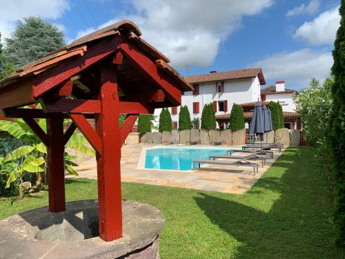 un nichoir rouge assis à côté d'une piscine dans l'établissement Hotel Restaurant Txistulari, à Itxassou