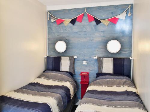 two beds in a room with flags on the wall at Castle Street in Llanystumdwy