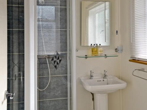 a bathroom with a sink and a shower at Castle Street in Llanystumdwy