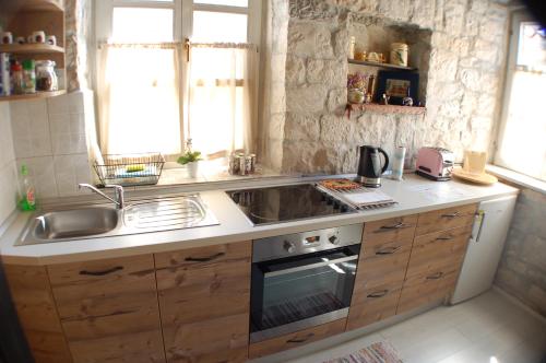 a kitchen with a sink and a stove at Apartment Tragurium in Trogir