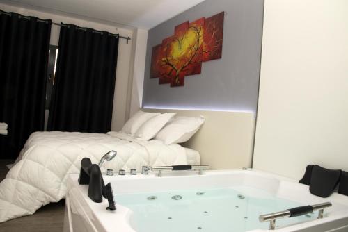 1 dormitorio con cama y bañera en Alcalá del Jucar Hotel Pelayo, en Alcalá del Júcar