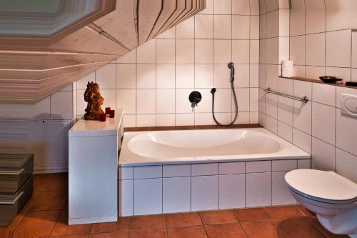 a bathroom with a tub and a toilet at Panoramahaus am Schlipfweg in Weil am Rhein