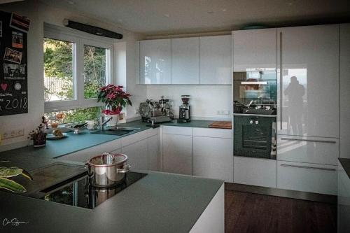 a kitchen with white cabinets and a stove top oven at Panoramahaus am Schlipfweg in Weil am Rhein
