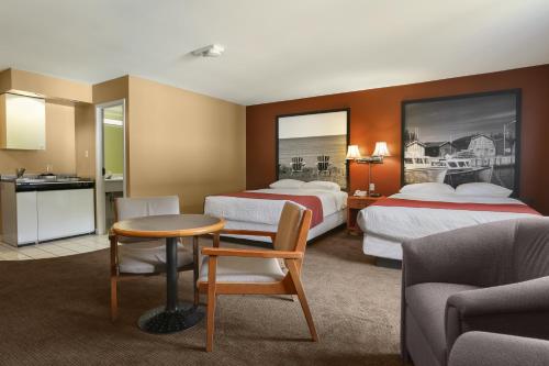 a hotel room with two beds and a table at Super 8 by Wyndham North Bay in North Bay