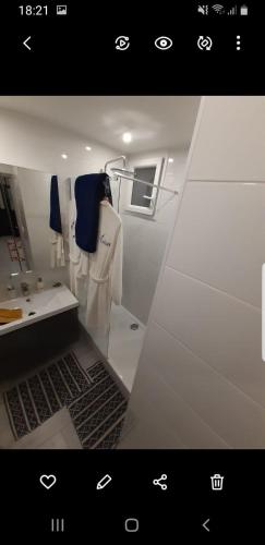 La salle de bains est pourvue de serviettes blanches et d'un lavabo. dans l'établissement Confortable Apt 10 min des plages, au Cannet
