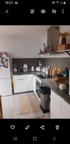 une cuisine avec des armoires blanches et un comptoir dans l'établissement Confortable Apt 10 min des plages, au Cannet