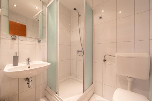 a bathroom with a sink and a toilet and a shower at Villa Filip in Živogošće