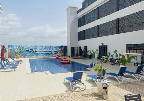 ein Pool mit Stühlen und ein großes Gebäude in der Unterkunft ONYX HOTEL Yamoussoukro in Yamoussoukro