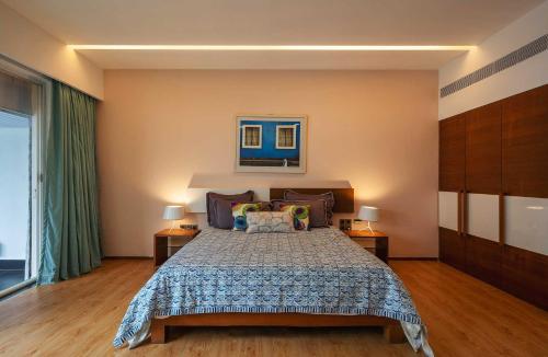 a bedroom with a bed and two lamps and a window at Isle View by VEO - Part of StayVista in Dabolim