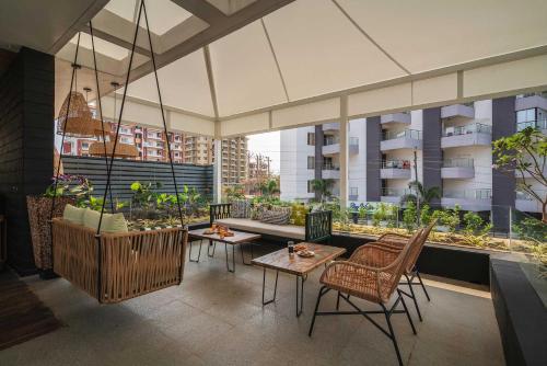 a balcony with tables and chairs on a building at Isle View by VEO - Part of StayVista in Dabolim