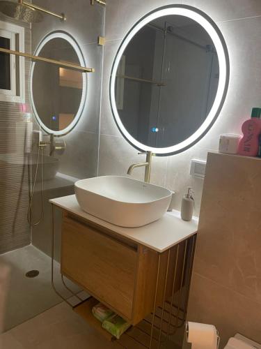 łazienka z umywalką i 2 lustrami w obiekcie Milan suit w mieście Or Yehuda