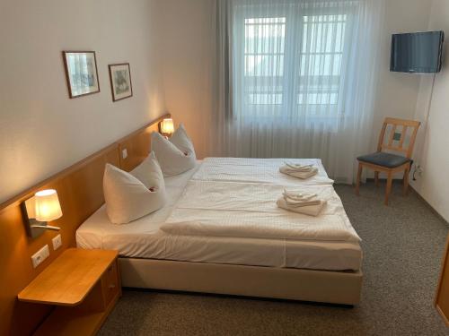 a bedroom with a bed with white pillows and a chair at Apartment Jette mit Balkon in Zempin