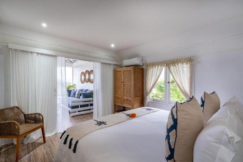 a bedroom with a large white bed and a window at Beach Tonic Lembongan in Nusa Lembongan