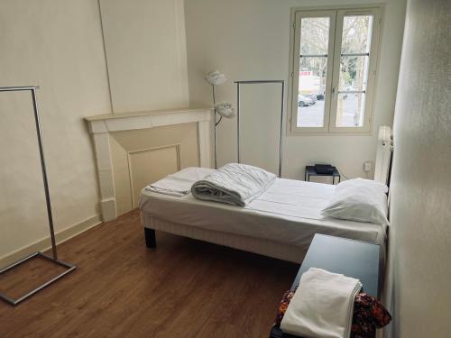 een kleine slaapkamer met een bed en een raam bij l'appartement de Chinon in Chinon