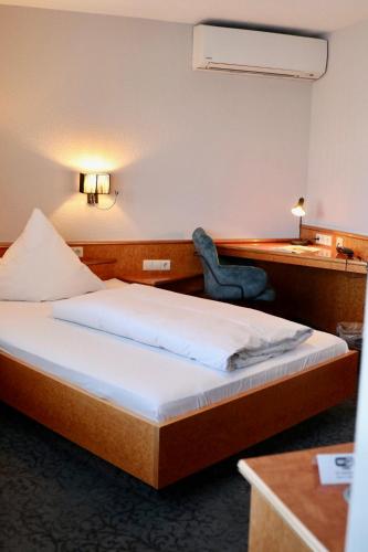 a hotel room with a bed and a desk and a chair at Hotel Württemberger Hof in Reutlingen