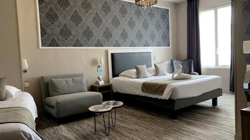 Habitación de hotel con cama y silla en Hotel de France Citotel, en Rochefort