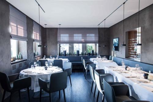 a dining room with white tables and chairs at Hotel Neckartal in Köngen