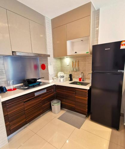 a kitchen with a black refrigerator and a sink at R&F PRINCESS COVE at ANJU in Johor Bahru