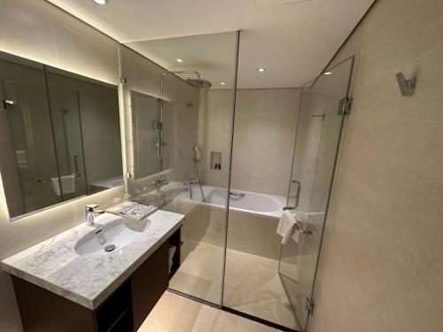 a bathroom with a shower and a sink and a tub at Hotel Yah Hanoi & Spa in Hanoi