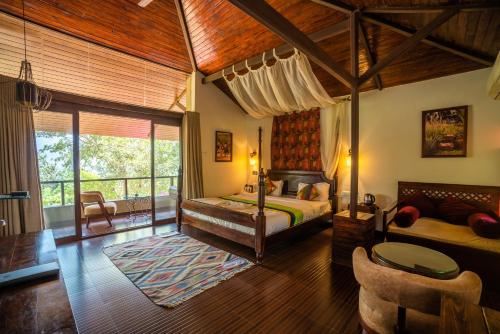 a bedroom with a bed and a living room at Malhar Machi Mountain Resorts in Mulshi