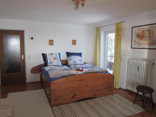 a bedroom with a wooden bed and a window at Ferienwohnung Annalena in Seebruck