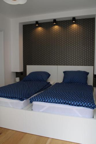 1 dormitorio con 2 camas y almohadas azules en Halo Green Apartament Wrocław, en Wroclaw