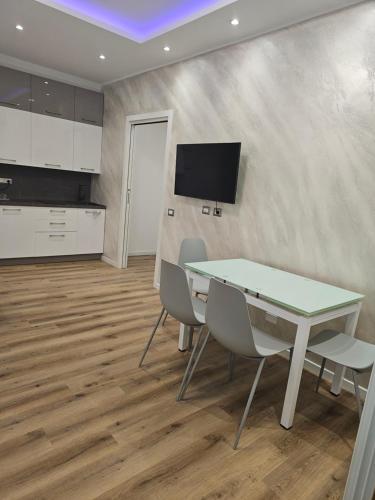a dining room with a table and chairs and a tv at Residence Laura in Cesano Boscone