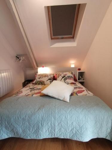 une chambre avec un lit dans un grenier dans l'établissement Gîte LA Maison LA, à Saint-Aubin-dʼAubigné
