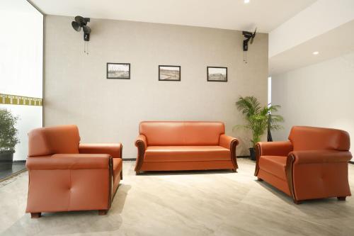 dos sillas naranjas en una sala de espera en TERRACE BUSINESS HOTEL KOZHIKODE, en Kozhikode