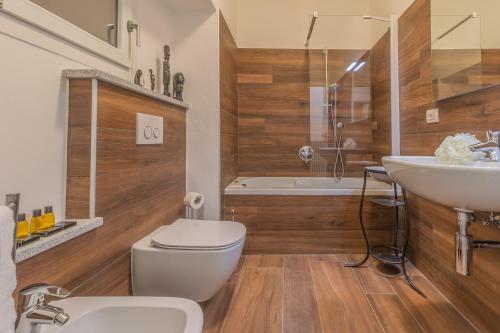 a bathroom with a toilet and a sink and a tub at Casa Ferrari in Varenna