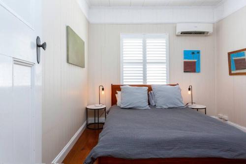 een slaapkamer met een groot bed met 2 nachtkastjes bij Garden Cottage 1Brm Private & Spacious in Brisbane