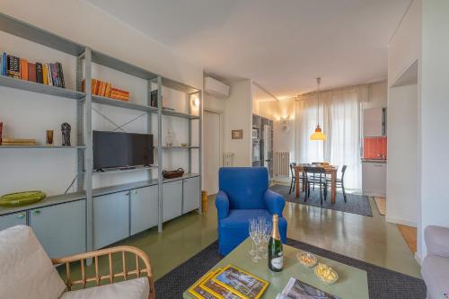 een woonkamer met een blauwe stoel en een tafel bij BnButler - Cesare Brivio, 21 - Ampio e Luminoso in Milaan