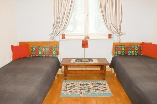 a room with two beds and a table and a window at Magdalene's house in Poros