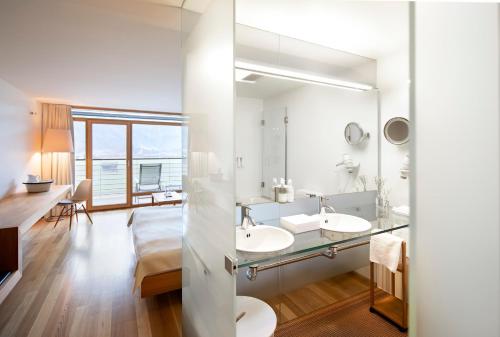 Hotel Post Bezau في بيزاو: حمام مغسلتين ومرآة