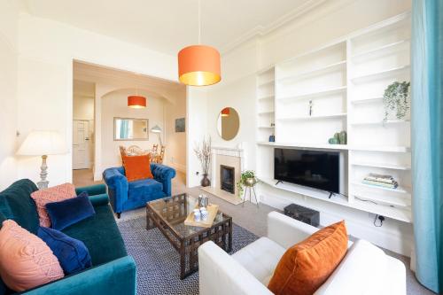 a living room with blue couches and a fireplace at Spacious and quiet ground floor flat in Bristol