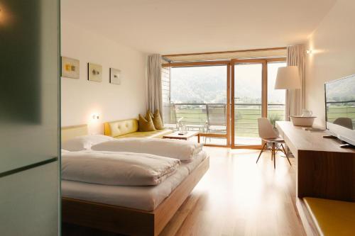 um quarto de hotel com uma cama, uma secretária e uma janela em Hotel Post Bezau em Bezau