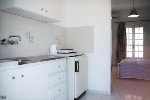 a white kitchen with a sink and a counter at Manao Summer House in Tsilivi
