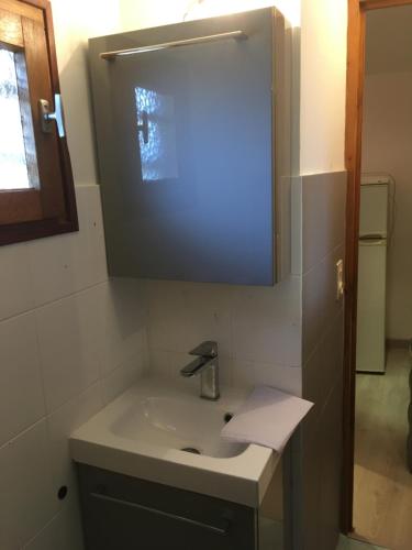 uma casa de banho com um lavatório e um espelho em Loué petit studio maisonnette em Marselha