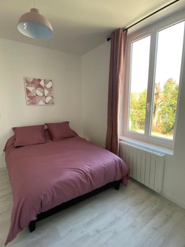 a bedroom with a bed and a large window at Pink Cosy in Louviers
