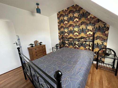 a bedroom with a bed with a patterned wall at Appartement au centre ville de Sens in Sens