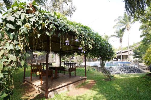 a gazebo with a table and chairs in a yard at Malhar Machi Mountain Resorts in Mulshi