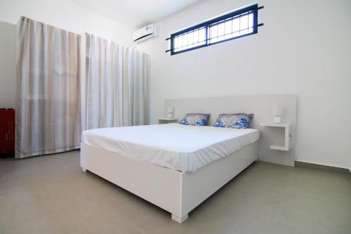 a white bedroom with a white bed and a window at Villa Cardinal, 4 chambres avec piscine privee in Pointe aux Biches